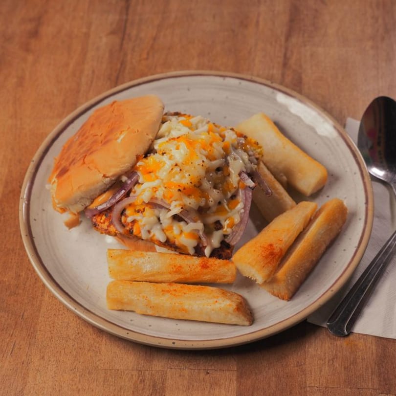 Pataka Indian Fusion Cuisine's cheesy chicken sandwich with onions and a side of crispy fries.