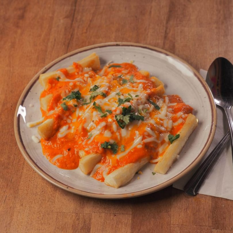 Pataka Indian Fusion Cuisine's cheesy fries, topped with a vibrant red sauce and fresh cilantro.